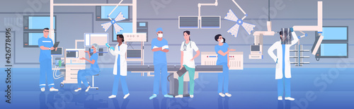 medical doctors team in uniform working together in operating room modern hospital clinic interior intensive therapy surgical procedures teamwork concept horizontal full length