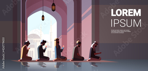 religious muslim men kneeling and praying inside mosque ramadan kareem holy month religion concept full length copy space horizontal
