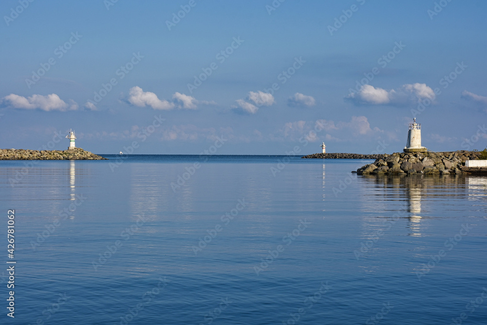 Two lighthouses facing each other in the port with clear sky and clouds