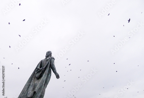 statue and flying birds