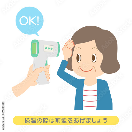 非接触体温計　前髪を上げて検温を受けるシニア女性