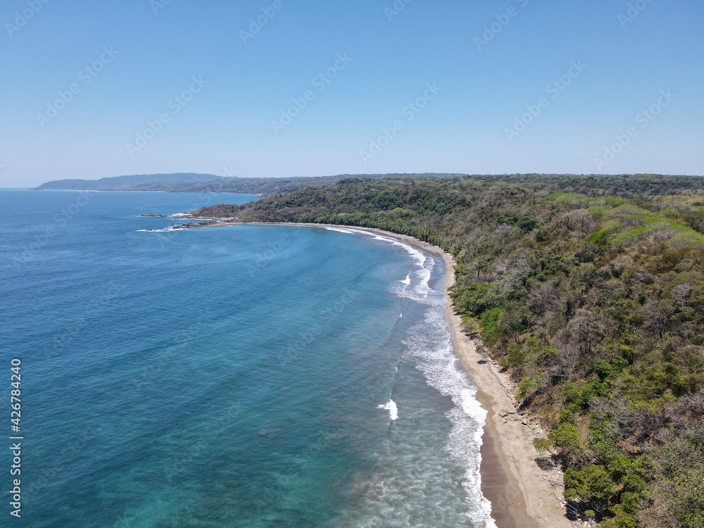 Lush Tropical Beach Paradise with blue water, great waves and rock formations in Montezuma Nicoya Peninsula Costa Rica