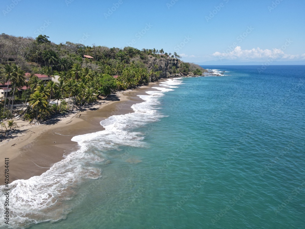Lush Tropical Beach Paradise with blue water, great waves and rock formations in Montezuma Nicoya Peninsula Costa Rica