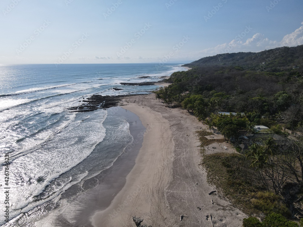 Lush Tropical Beach Paradise with blue water, great waves and rock formations in Malpais / Santa Teresa, Nicoya Peninsula Costa Rica	