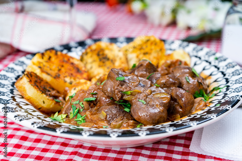 Beef kidney, leek and onion stew with Spanish style potatoes served on a vintage plate. Beef kidney, leek and onion stew with Spanish style potatoes served on a vintage plate.