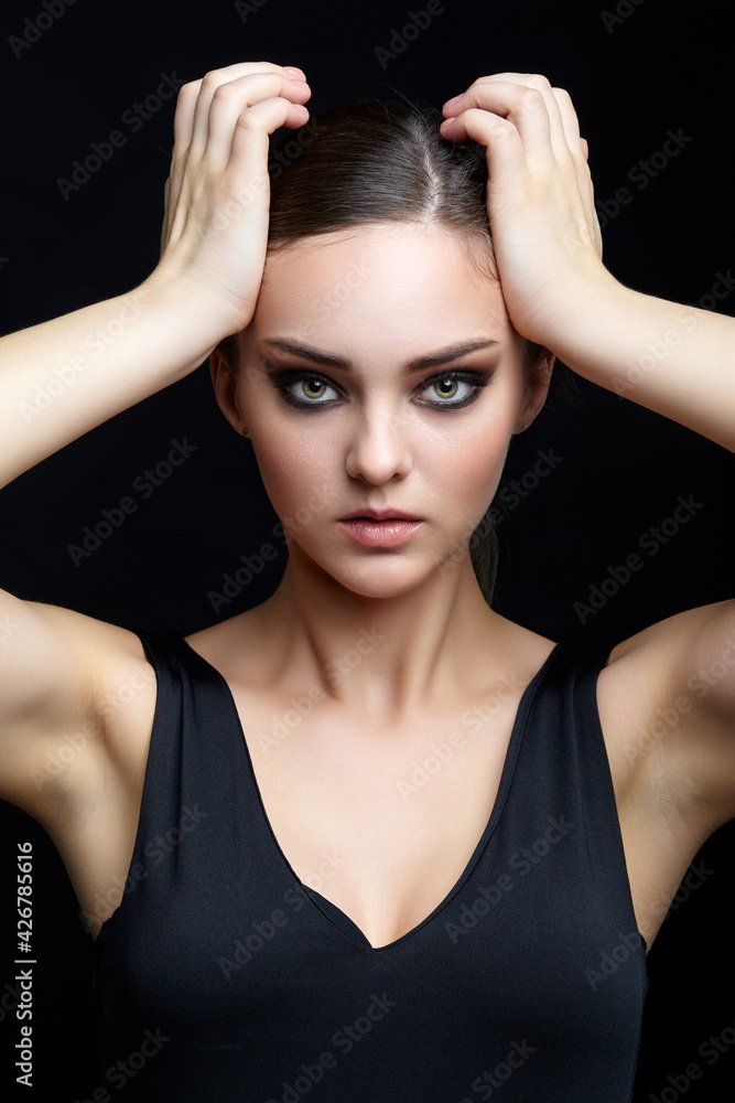 Beauty portrait of young woman. Brunette girl with evening female makeup and black dress Beauty portrait of young woman. Brunette girl with evening female makeup and black dress