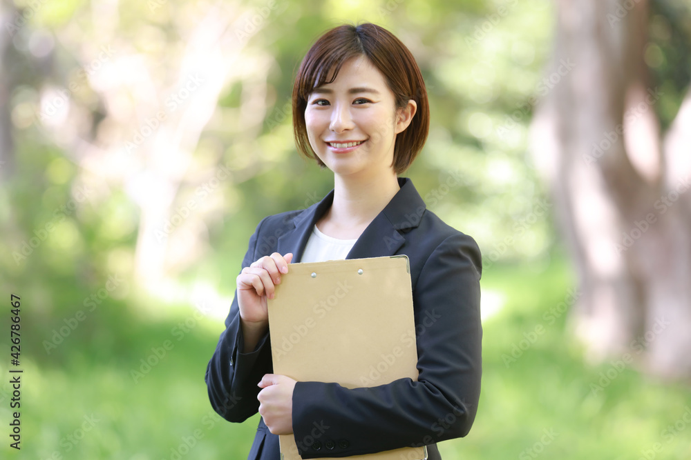 バインダーを持つ女性社員