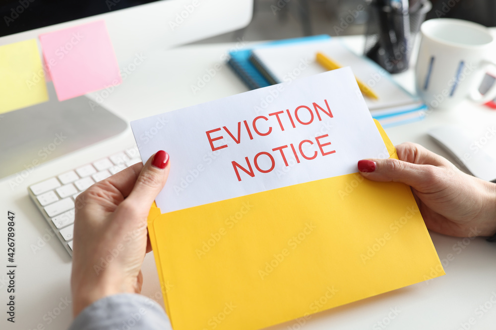 Woman sitting at table and holding eviction letter closeup Woman sitting at table and holding eviction letter closeup