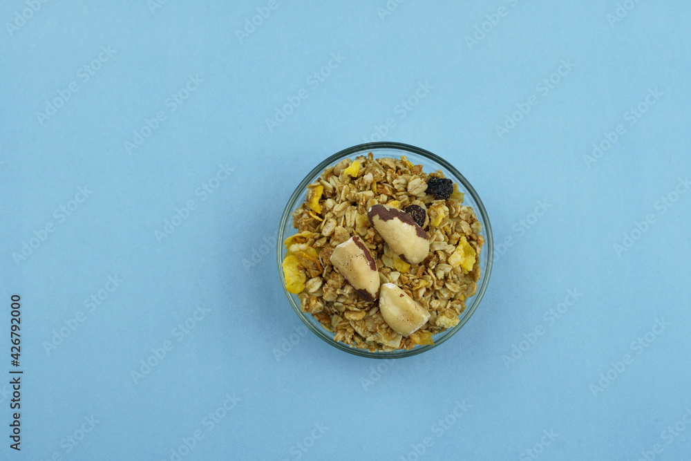 Chestnut and granola in a bowl. Top view on blue background Chestnut and granola in a bowl. Top view on blue background