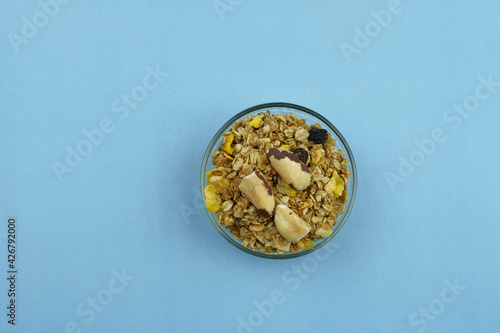 Chestnut and granola in a bowl. Top view on blue background