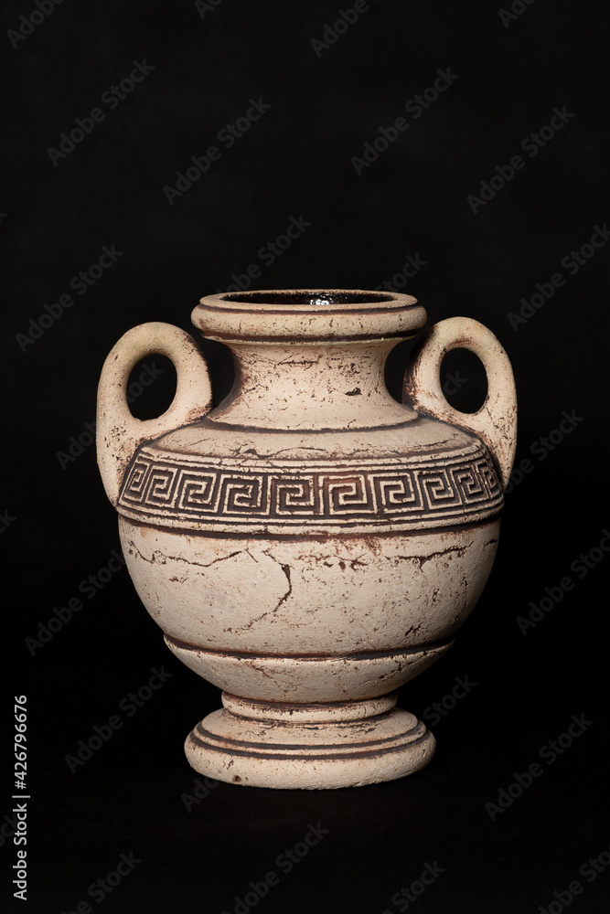 Amphora stands on a black background in a room in the studio