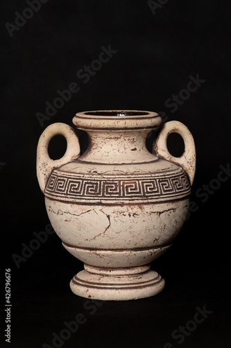 Amphora stands on a black background in a room in the studio