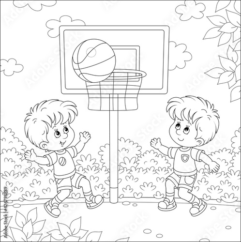 Cheerful little kids playing basketball with a big ball on a sports ground in a park on summer vacations, black and white vector cartoon illustration for a coloring book page