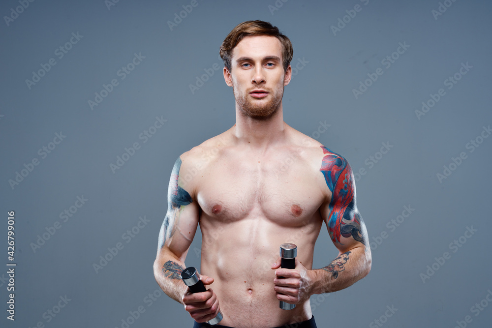 Fototapeta premium handsome man blond Sport Fitness pumped-up torso dumbbells model