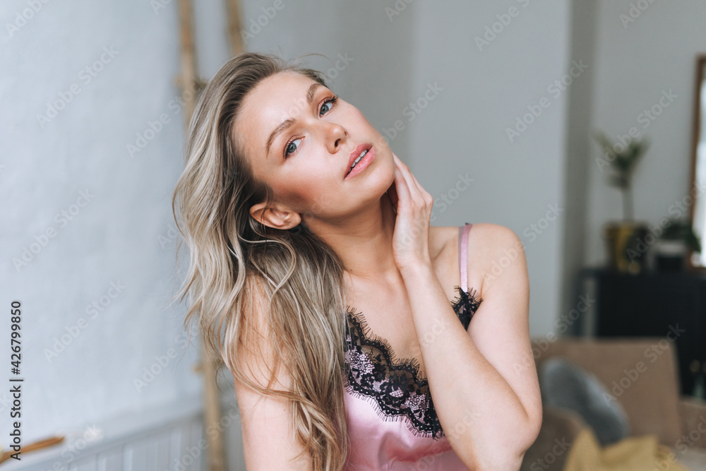 Beauty portrait of blonde smiling woman 35 year clean fresh face and hands with long hair in light bathroom