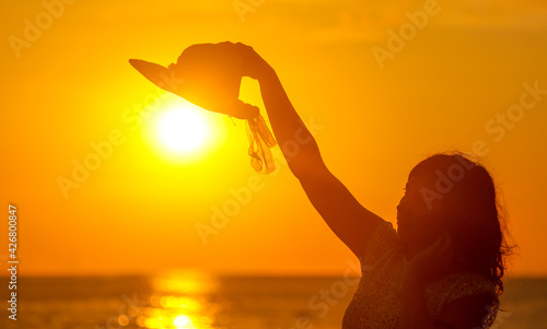 The girl puts on a hat in the sun in the sea