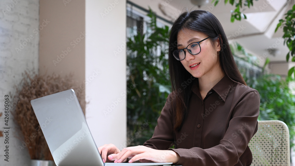 Smiling young woman working or surfing internet with computer laptop. Smiling young woman working or surfing internet with computer laptop.