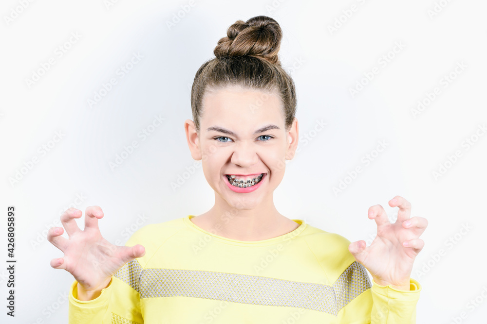 Girl smiling showing tiger with hands. The concept of dentistry and installing braces on the teeth. Girl smiling showing tiger with hands. The concept of dentistry and installing braces on the teeth.