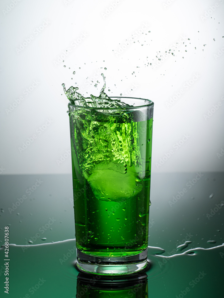 tall transparent glass with green tarragon lemonade on a light background tall transparent glass with green tarragon lemonade on a light background