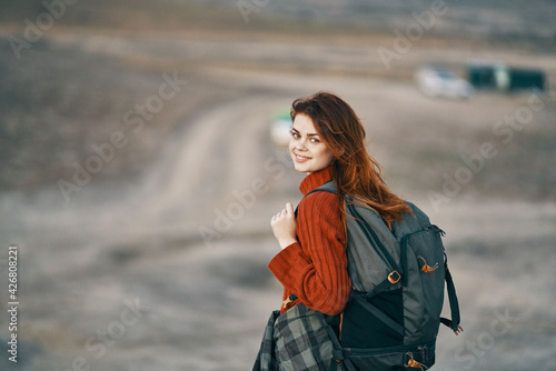 pretty woman with backpack resting in the mountains outdoors back view tourism model