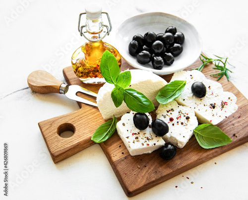 A fresh ricotta with basil leaves and olives