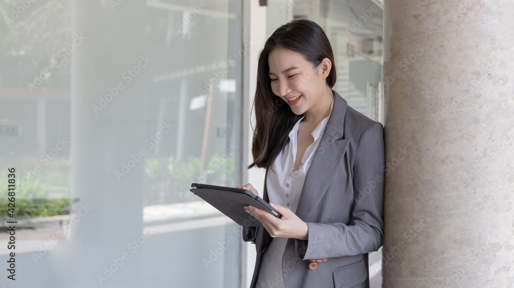 Young Asian business women communicate with business partners through tablets, Talking with wireless technology, Business data analysis using a tablet, Digital document. Young Asian business women communicate with business partners through tablets, Talking with wireless technology, Business data analysis using a tablet, Digital document.