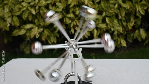 abstract metal toy symbol of perpetual motion machine on green background