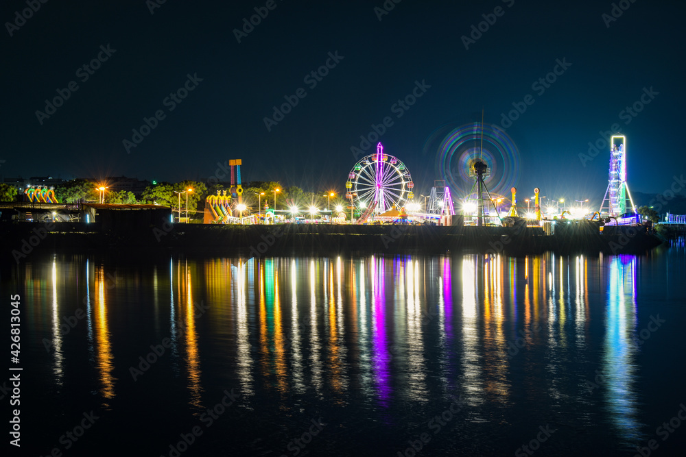 The spectrum of colours from the fair accompanied by their reflections on the river gives the frame an appealing look. 