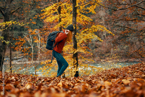 woman in a sweater jeans and with a hat on her head landscape fallen leaves model