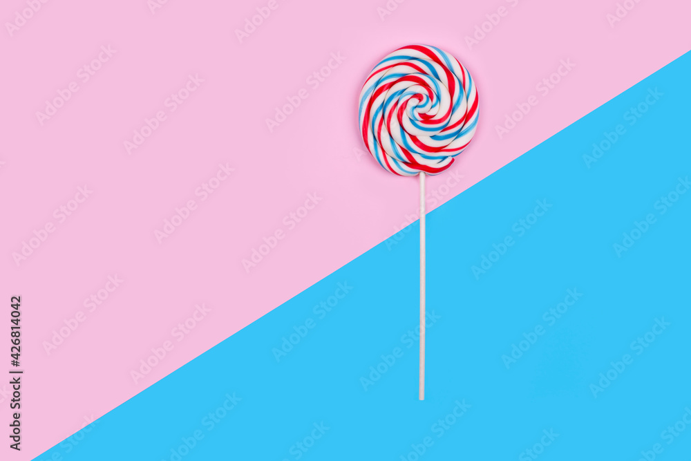 Colorful lollipop on pink and blue pastel background Colorful lollipop on pink and blue pastel background