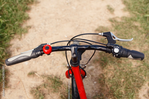 Bicycle handlebars on a trail background. Cycling in nature