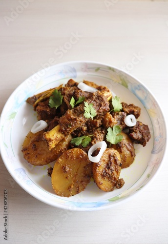 Mutton ghee roast. Goat meat fry with potatoes, also known as Mutton Batata bhujing. Spicy non-vegetarian lamb fry dish. Mutton curry or mutton fry. copy space.
