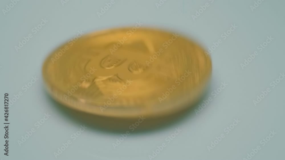Metallic, golden color, Bitcoin coin is jumping on a light surface, sparkling in the light. Hodl, Hodler - Internet meme, slang name for those who buy cryptocurrencies and hold them. Macro. Closeup Metallic, golden color, Bitcoin coin is jumping on a light surface, sparkling in the light. Hodl, Hodler - Internet meme, slang name for those who buy cryptocurrencies and hold them. Macro. Closeup