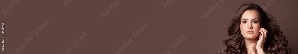 Pretty woman with healthy skin and long perfect dark hair on brown banner background Pretty woman with healthy skin and long perfect dark hair on brown banner background