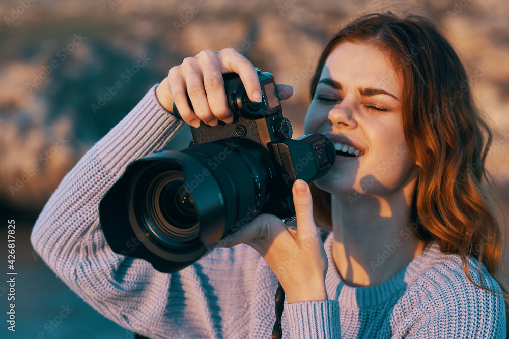 happy woman photographer with camera in mountains on nature and river in the background happy woman photographer with camera in mountains on nature and river in the background