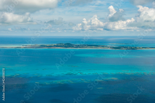 Fototapeta Naklejka Na Ścianę i Meble -  Incredible view of the island of Kohama surrounded by deep turquoise blue, full of corals seen from an airplane.
