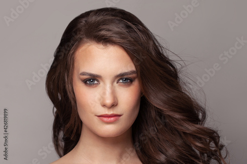 Pretty woman face with curly brown hair portrait