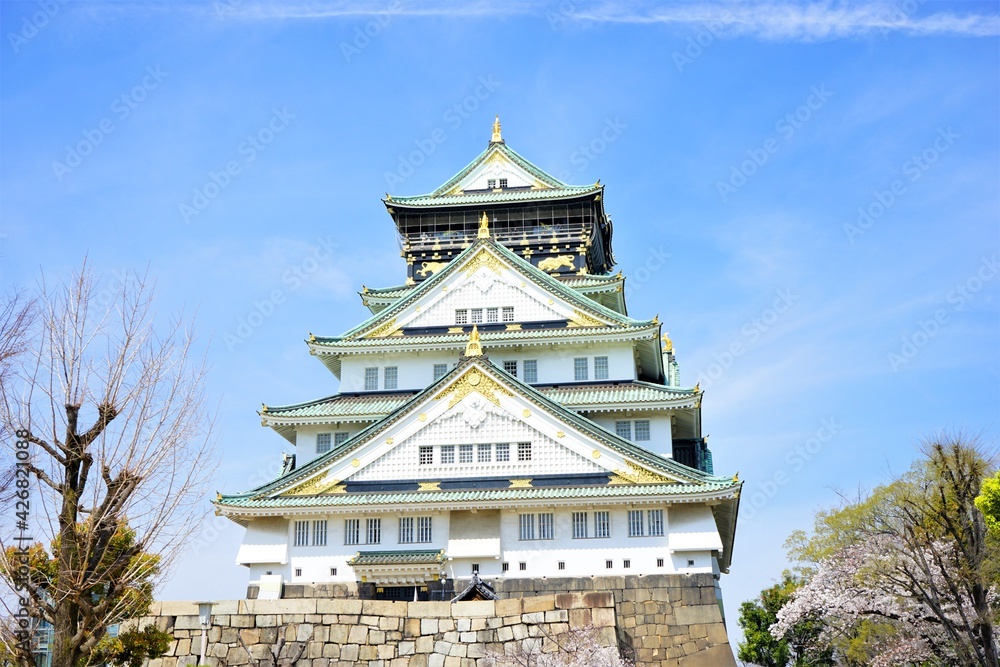 Osaka, Japan - March 2021: Osaka Castle (Osakajo) with pink cherry blossoms over blue sky background during spring - 大阪城 桜 日本 Osaka, Japan - March 2021: Osaka Castle (Osakajo) with pink cherry blossoms over blue sky background during spring - 大阪城 桜 日本