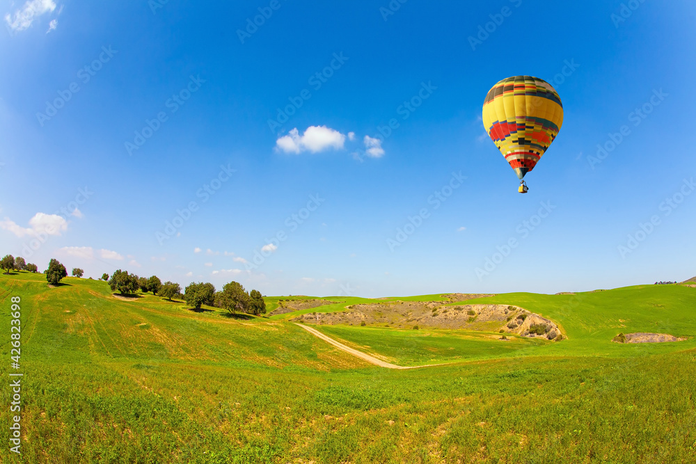 Fototapeta premium Bright hot air balloon flies