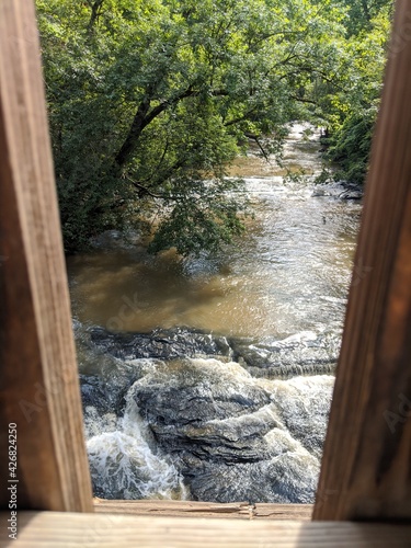 flowing creek through bridge posts