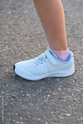 female foot in white sport shoe