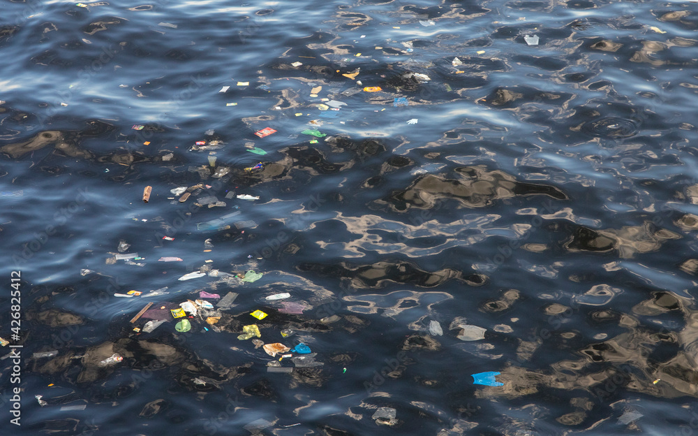 Garbage in the sea. Ecological problem. Trash in sea water. Plastic bags in ocean. Ecological problem. Urban seaside pollution. Human activity influence to wild life and natural environment.