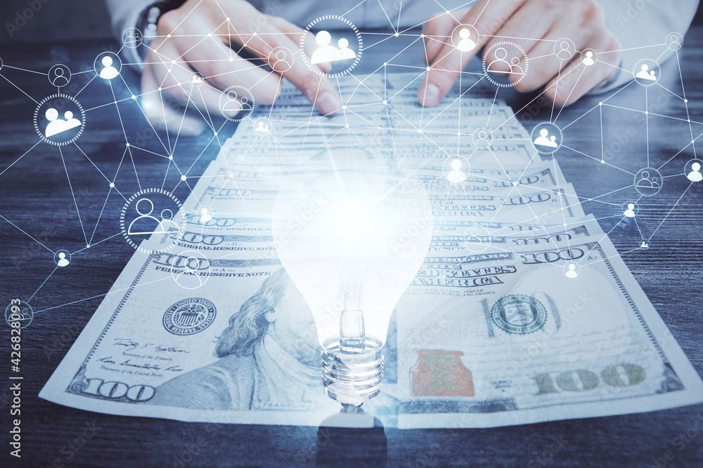 Multi exposure of bulb drawing hologram and USA dollars bills and man hands. Business Idea concept. Multi exposure of bulb drawing hologram and USA dollars bills and man hands. Business Idea concept.