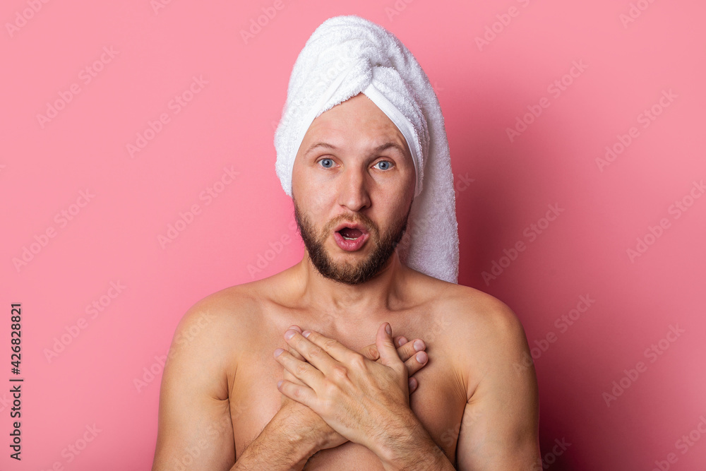 surprised nude young man with towel on head, holding crossed arms on chest on pink background surprised nude young man with towel on head, holding crossed arms on chest on pink background