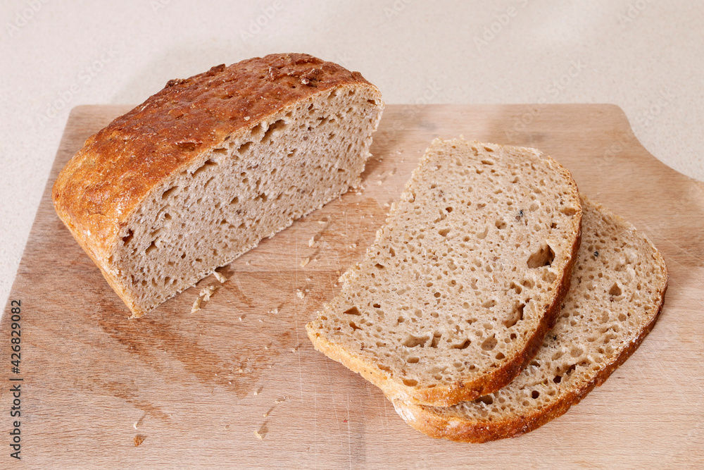 Loaf and slices of bread on the table.