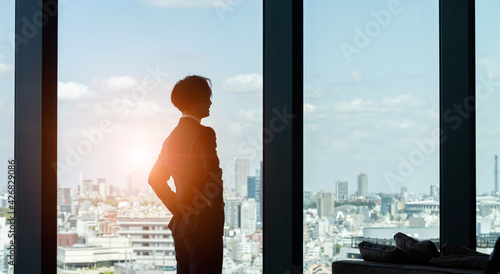 窓から街を眺めるビジネスマン © metamorworks