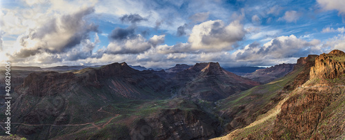 Panorama of rocky peaks with ravines at sunset