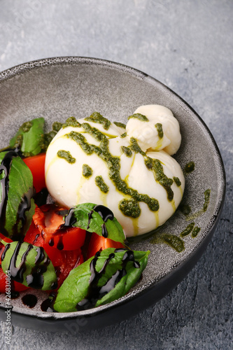 buratta. salad with buratta, pesto, basil, tomatoes and balsamic. caprese salad with buratta