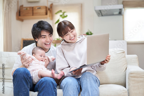 オンラインで親族に赤ちゃんを見せるアジア人ファミリー