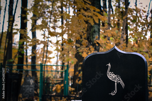 bird painted on tombstone. Muslim grave in an Islamic cemetery. graveyard background photo